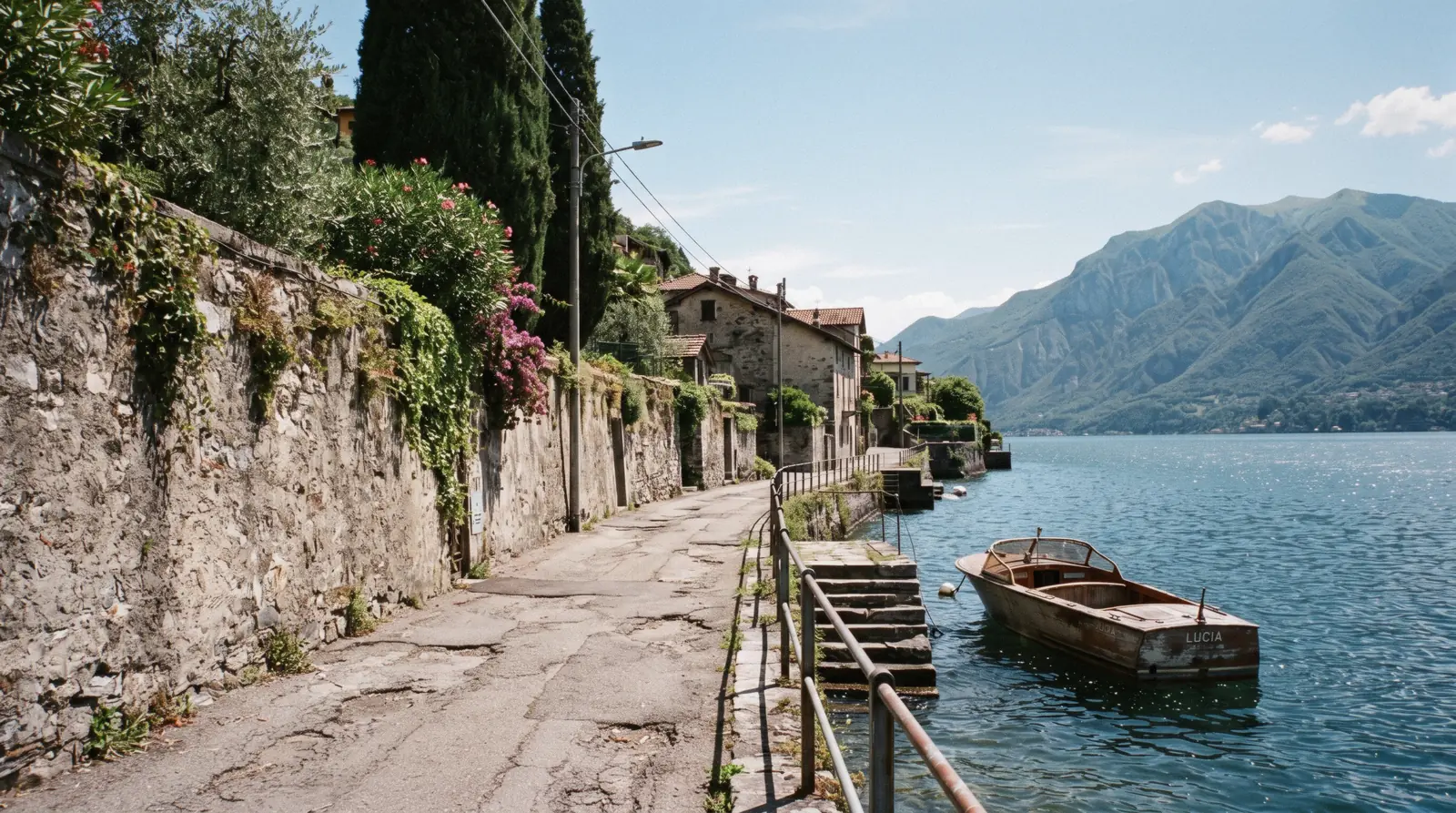 The narrow shelf of houses at Laglio between the SS340 road and the water on the western shore of Lake Como, seen from the lake