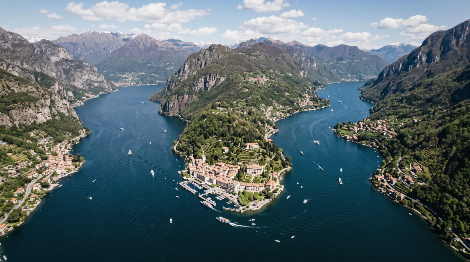 Aerial view down the narrow Como branch of the lake with mountains falling into the water, the shape that decides the Lake Como or Lake Garda question