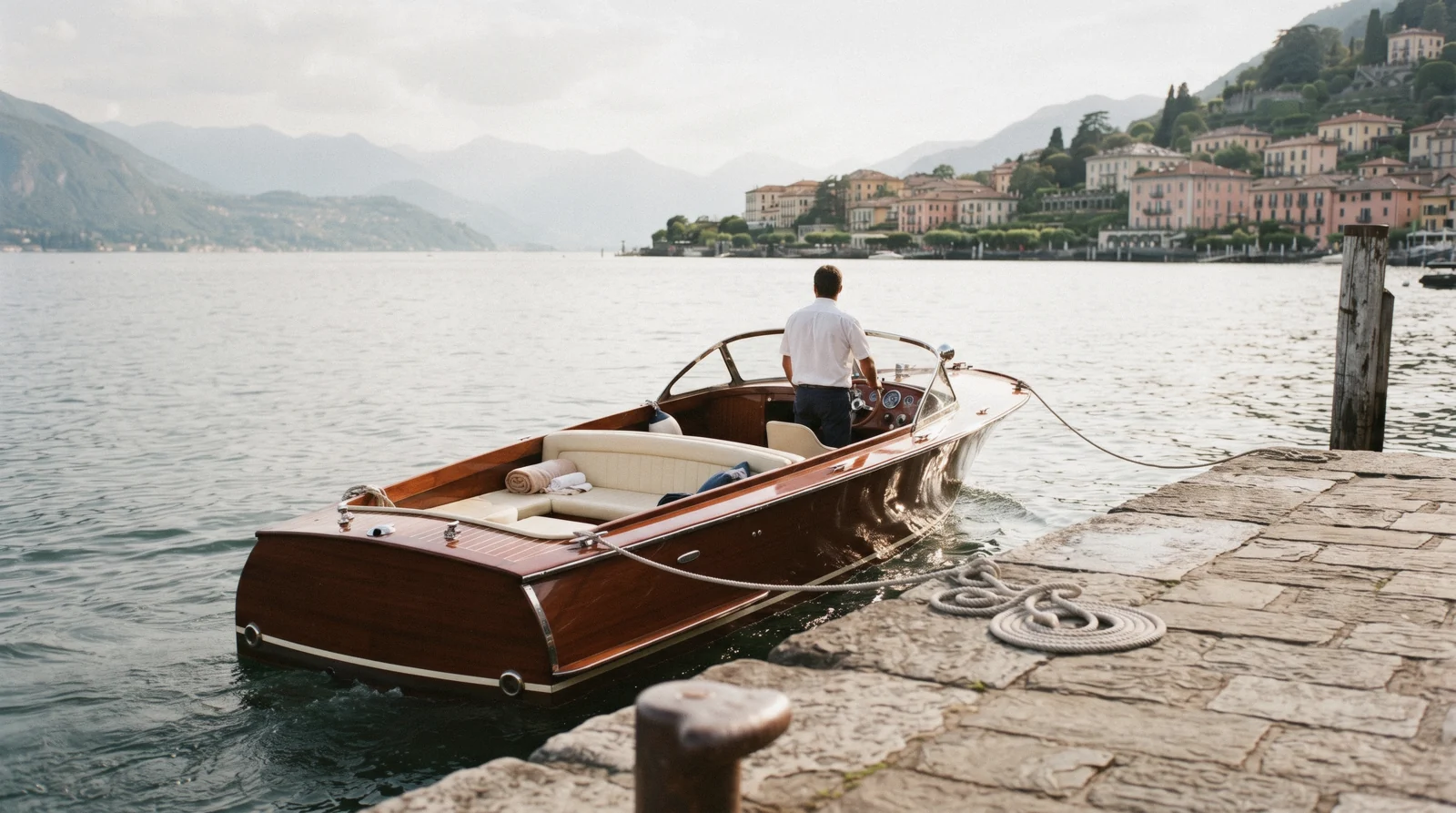 a varnished wooden runabout at a stone jetty in Bellagio, Lake Como private boat tour