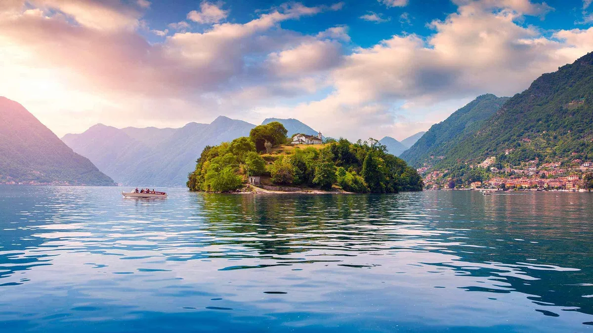 Shared cruise boat leaving Bellagio past lakeside villas on Lake Como