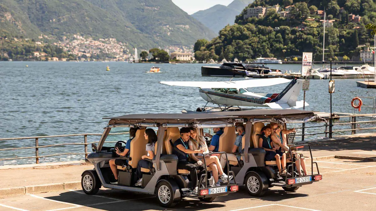 Open electric golf cart on a city tour past Villa Olmo in Como on Lake Como